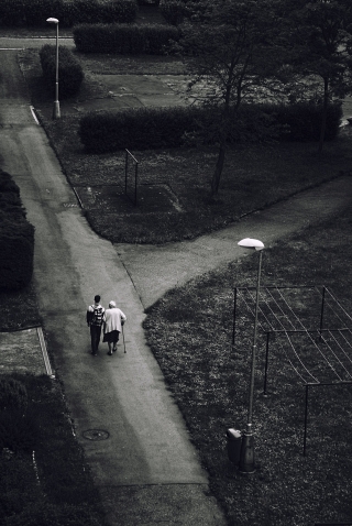 Young man helping elderly woman taking a walk